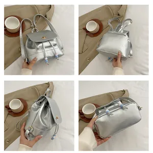 Detail view of silver mini backpack showing mirror finish and Saturn metal buckle