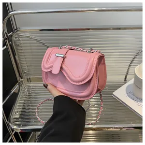 Detailed view of pink leather handbag with wave flap and silver chain strap