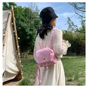 Detail of pink mini backpack with metal twist lock and drawstring in outdoor setting