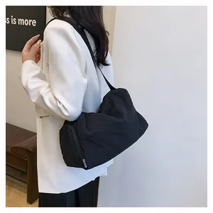 Gros plan d'un sac bandoulière cylindrique noir en nylon avec sangle logo Fashion