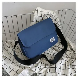 Close-up of blue canvas messenger bag inside a metal basket with adjustable strap