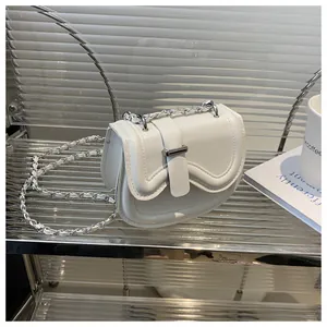 Close-up of white PU leather saddle bag with silver metal buckle on acrylic stand