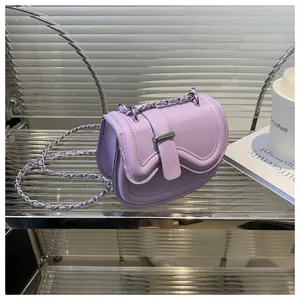 Close-up of light purple saddle bag with metal chain strap and silver buckle detail