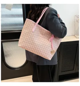 Detalle de bolso tote rosa con estampado de letras M y colgante de metal dorado en modelo