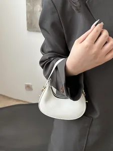 Detail of white litchi pattern mini crescent bag with golden metal zipper and hardware