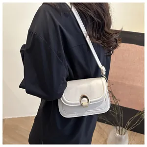 Detalle de bolso silla retro con hebilla de herradura dorada y cuero blanco suave