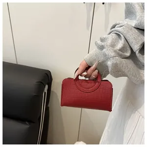 Close-up of red crocodile pattern mini handbag with unique hollow circular handle
