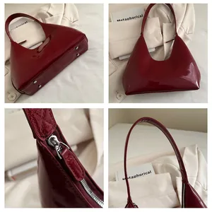 Détail du sac en cuir verni bordeaux montrant le fini brillant, le zip argenté et les picots