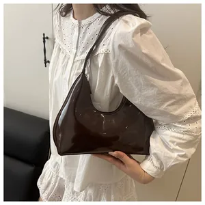 Détail du sac hobo en cuir verni marron foncé brillant avec gaufrage LULU sur le devant