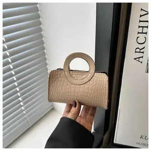 Macro detail of beige crocodile pattern texture on a stylish mini PU leather handbag