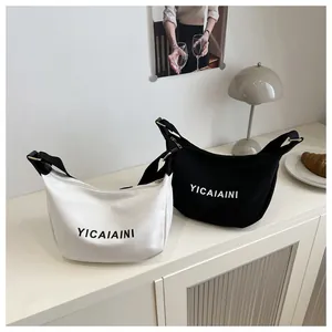 Sacs demi-lune en toile noir et blanc avec larges bandoulières pour un look décontracté