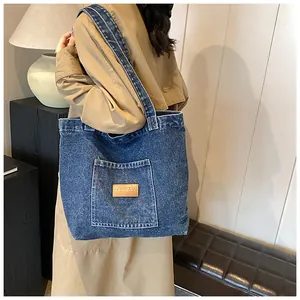 Side view of large denim tote bag showing its spacious design and vintage wash texture