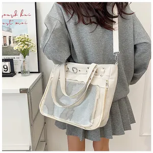 Detail of cream canvas ita bag with transparent PVC pocket and metal heart buckle
