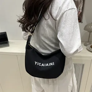 Sac bandoulière en toile noire en forme de croissant avec lettrage blanc élégant