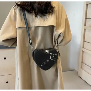 Vue détaillée du sac en cuir PU noir en forme de cœur avec rivets et boucle en métal