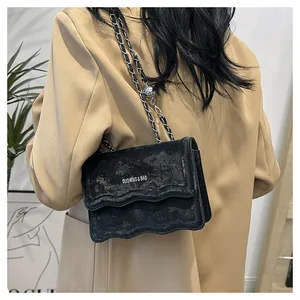 Détail du sac bandoulière noir mat avec chaîne et boucle de réglage en bille argentée