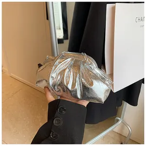 Close-up of silver pleated clutch bag with metallic PU finish held by a model