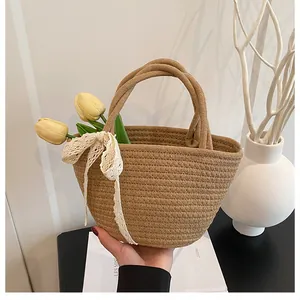 Gros plan d'un sac cabas tissé avec un nœud en dentelle blanche et texture en spirale