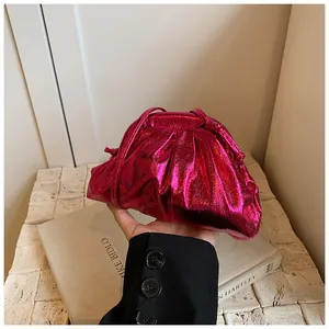 Macro shot of rose red metallic pleated clutch bag with fine straps and glossy finish