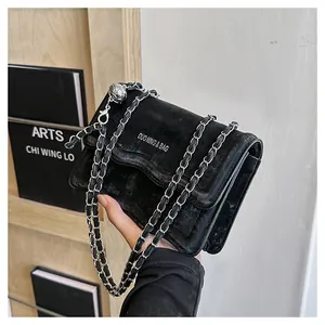 Détail de sac bandoulière noir avec boucle boule argentée et sangle en chaîne métal
