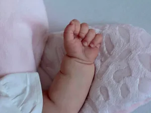 Close-up of lifelike newborn doll hand with realistic skin texture and fingernails