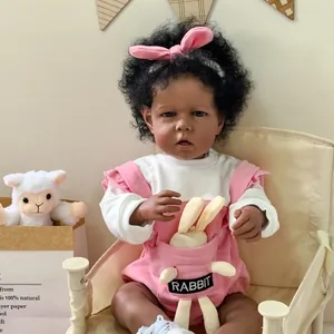 Muñeco Reborn Liam de 50cm con piel oscura, pelo rizado negro y diadema de conejo rosa