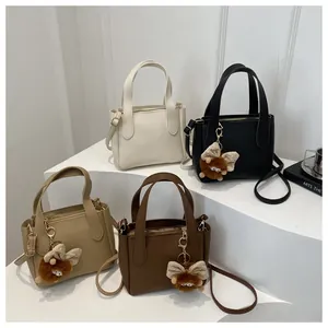 Detail view of retro bucket bags in four colors with lychee texture and plush charms
