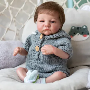 Realistic 49cm Levi Awake reborn doll in grey knit outfit on a cozy swing chair