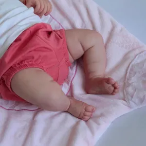 Lifelike 50cm reborn baby doll with soft fabric body and realistic hand-painted skin details
