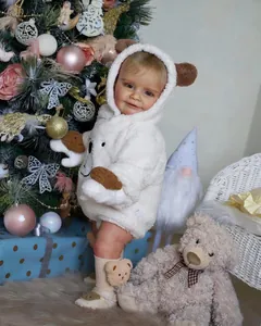 Detailed view of plush baby romper with bear ears and matching socks in Christmas setting