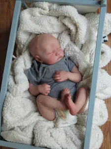 Lifelike sleeping reborn baby doll Levi with 3D skin texture on soft white fleece carpet