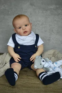 Detailed view of 60cm lifelike reborn doll wearing navy knit romper with plush bear