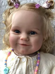 Gros plan d'une poupée reborn réaliste avec boucles dorées et yeux bleus en cardigan