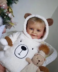 Close-up of Zoe reborn baby doll wearing a white plush bear hoodie with blue eyes