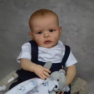 60cm realistic Sandie reborn baby doll in navy overalls with a plush bear toy