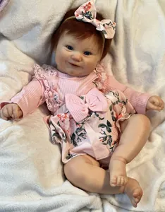 Close-up of 50cm lifelike reborn baby doll Maddie with blue eyes and floral pink outfit