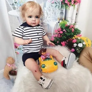 Realistic Maggi Boy Reborn Doll with golden curls and striped polo on white fur rug