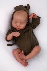 Detailed view of sleeping reborn baby doll in dark green hooded romper with cute ears