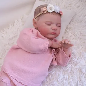 Realistica bambola Reborn Quinlyn da 19 pollici con maglione rosa e fascia floreale