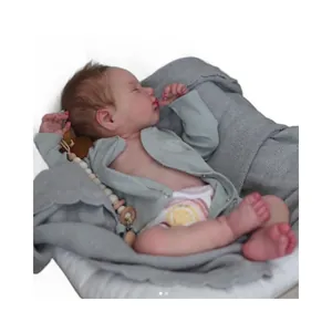 Realistische 19 inch Loulou reborn babypop in grijs vest op zachte witte kussens