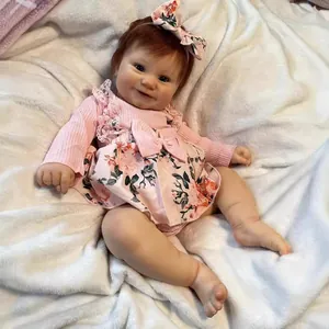 50cm lifelike newborn baby doll Maddie with red hair and floral dress on white plush rug