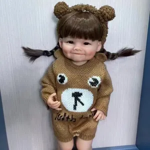 Bambola reborn realistica da 55cm con capelli castani e vestito in maglia a orsetto