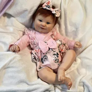 Lifelike 50cm Maddie Reborn baby doll in pink floral dress on soft white fur background