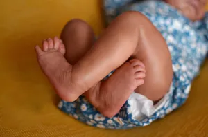 Close-up detail of realistic skin texture and tiny feet on 49cm reborn baby doll