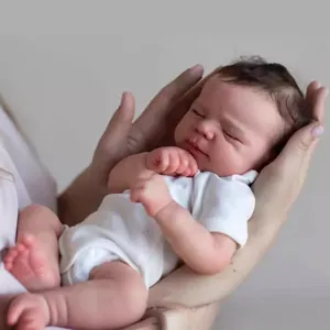 Lifelike 50cm Reborn Baby Doll in white bodysuit sleeping peacefully in hands