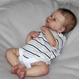 Realistic Elijah reborn baby doll with 3D skin and striped shirt on soft gray fabric