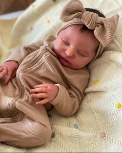 Dettaglio bambola reborn da 20 pollici con tutina kaki su coperta in maglia beige