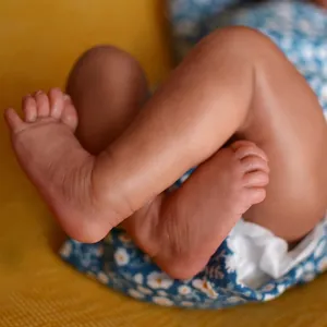 Realistic 49cm African American Reborn Baby Levi with detailed skin folds and floral outfit