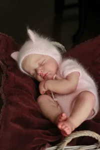 Gros plan sur le visage réaliste du poupon reborn avec peau 3D et bonnet tricoté