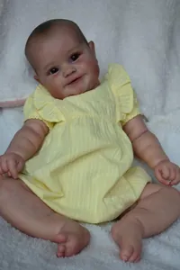 Detailaufnahme der 60cm Maddie Babypuppe im gelben Streifenkleid mit Rüschen und Textur